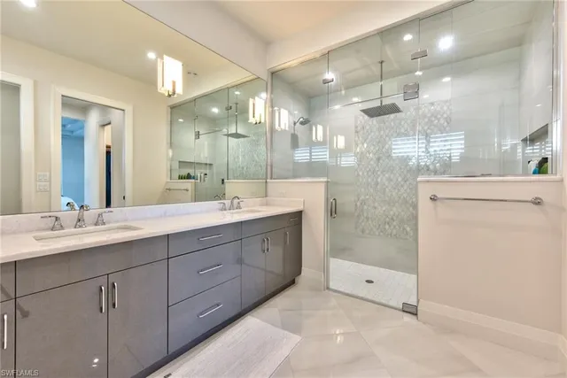 a bathroom with a double vanity sink mirror and shower