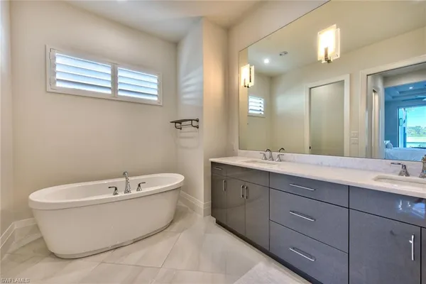 a spacious bathroom with a bathtub sink and mirror