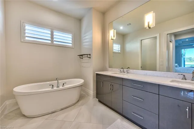 a spacious bathroom with a bathtub sink and mirror
