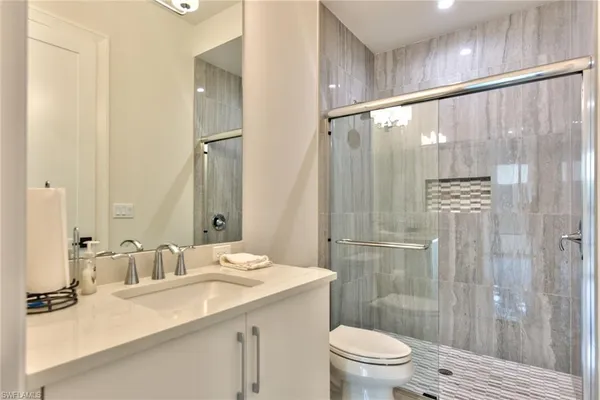 a bathroom with a granite countertop sink toilet and shower