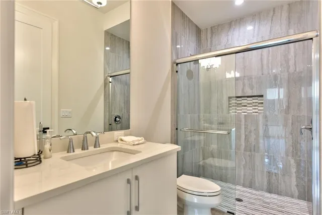 a bathroom with a granite countertop sink toilet and shower