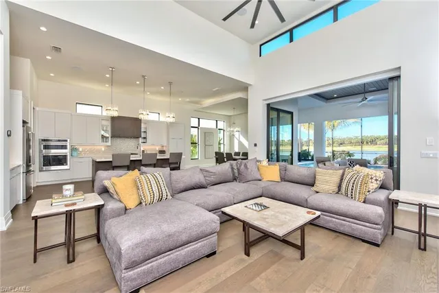 a living room with furniture kitchen view and a large window