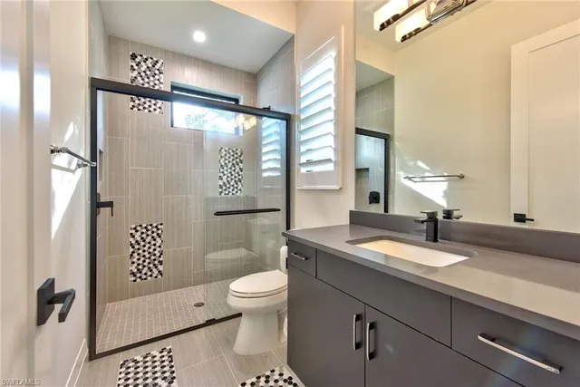 a bathroom with a sink a toilet and shower