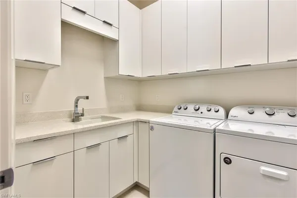 a utility room with sink dryer and washer