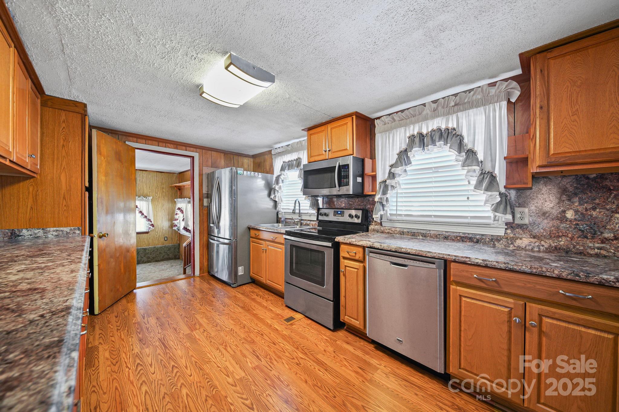 2601-2617 Olive Branch Road Monroe, NC 28110 - Photo 21 of 30 a kitchen with stainless steel appliances granite countertop a sink and wooden cabinets