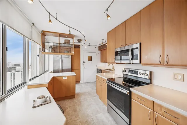a kitchen with stainless steel appliances a stove a sink and a refrigerator