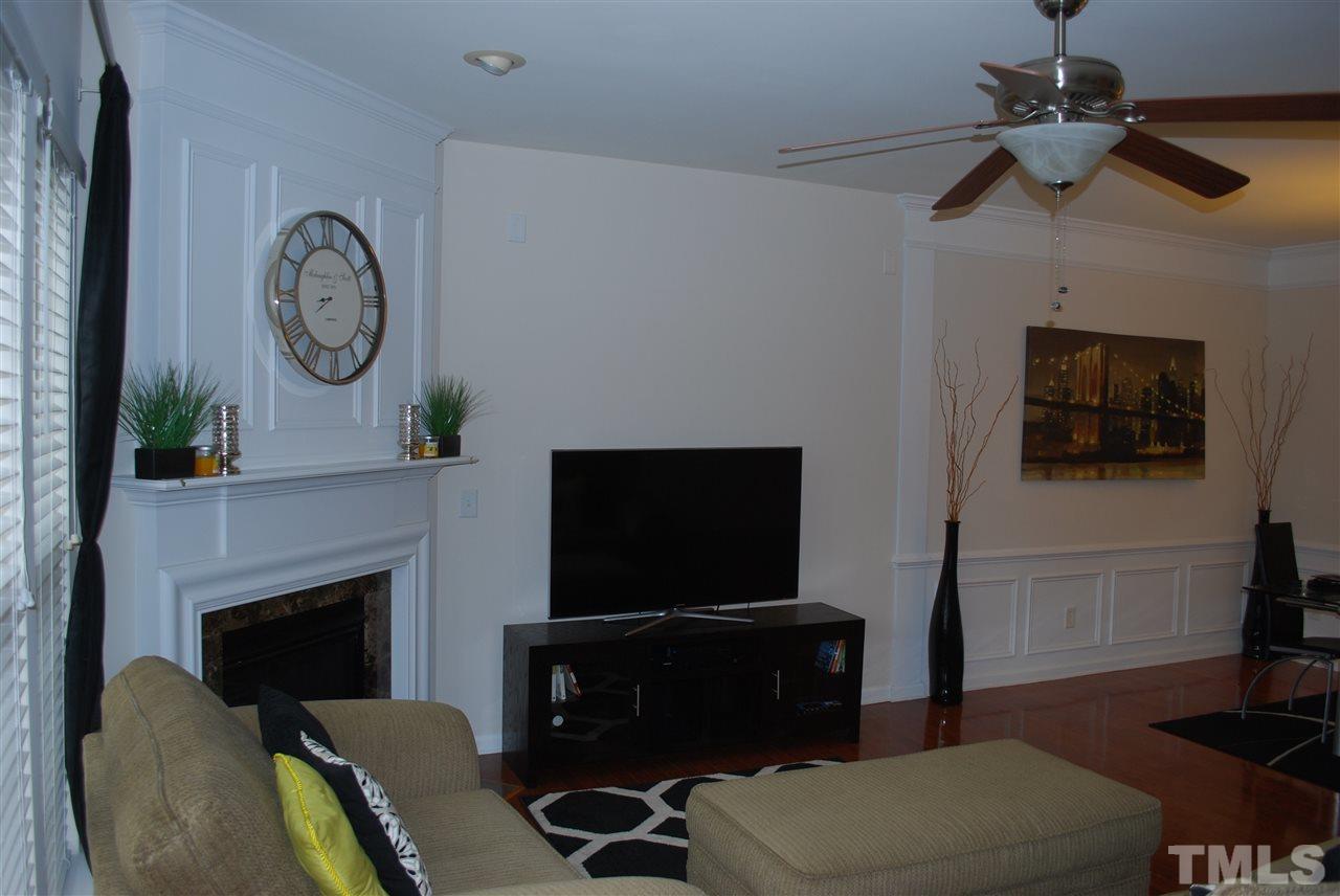 2619 Laurel Cherry Street Raleigh, NC 27612 - Photo 15 of 30 a living room with furniture a flat screen tv and a fireplace