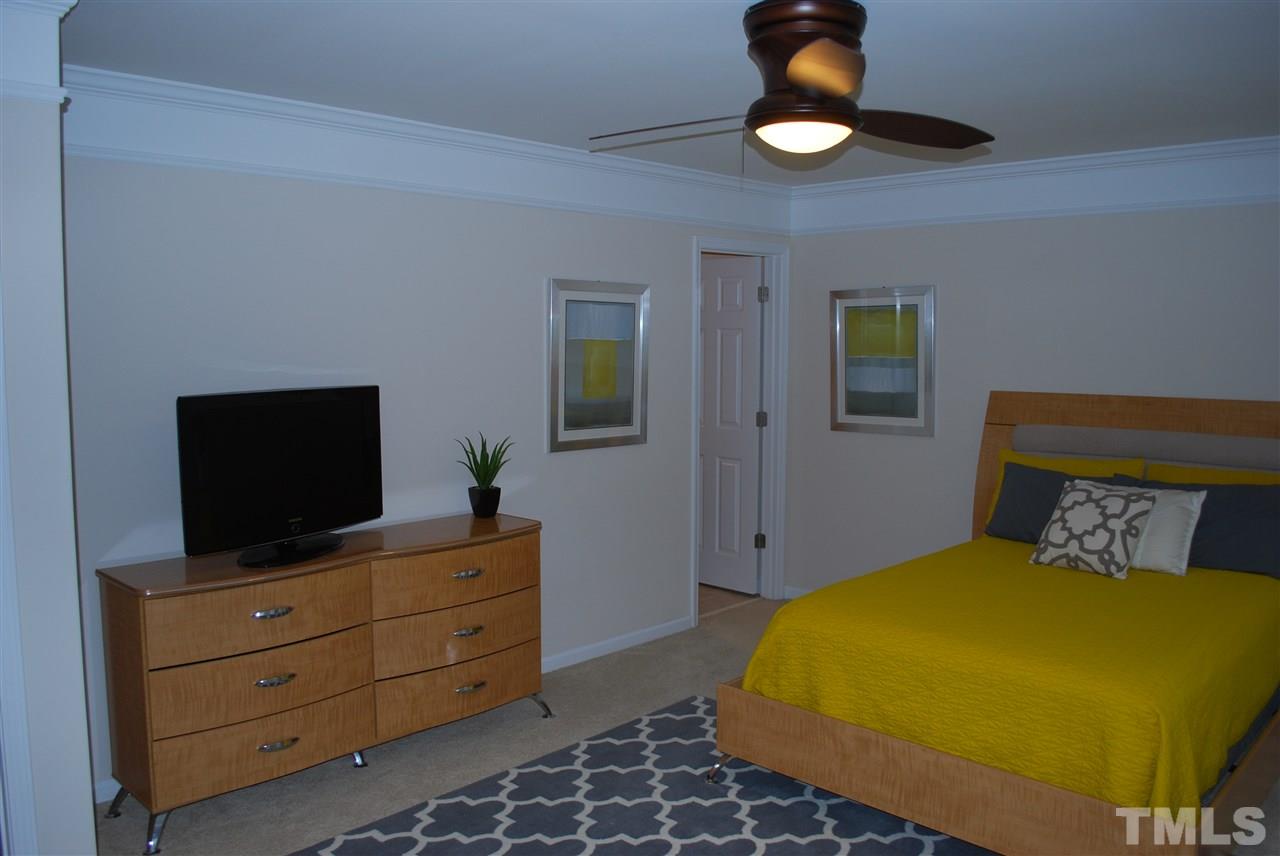 2619 Laurel Cherry Street Raleigh, NC 27612 - Photo 18 of 30 a bedroom with a bed and a flat tv screen on dresser