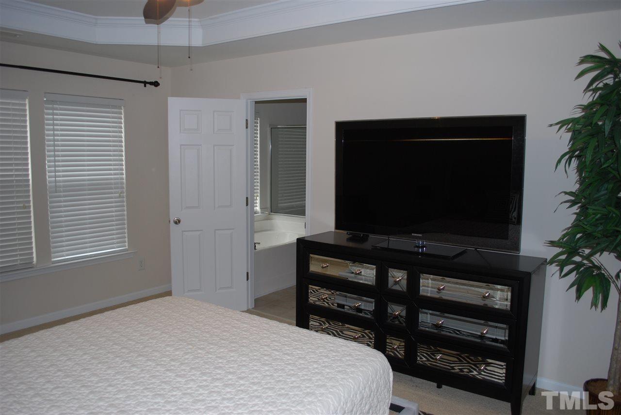 2619 Laurel Cherry Street Raleigh, NC 27612 - Photo 20 of 30 a bedroom with a bed and a flat screen tv