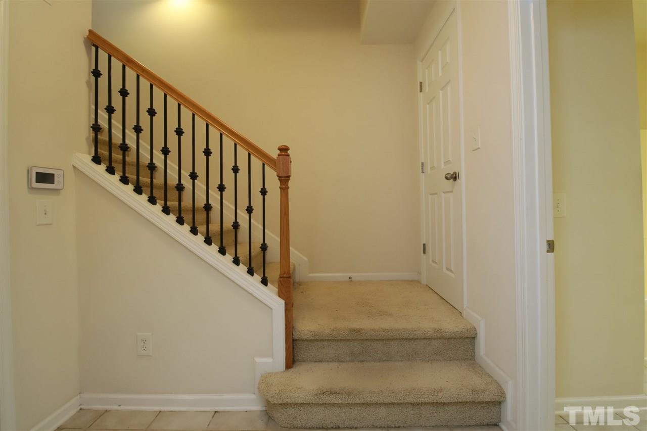 2619 Laurel Cherry Street Raleigh, NC 27612 - Photo 25 of 30 a view of staircase with lots of frames on wall and a window