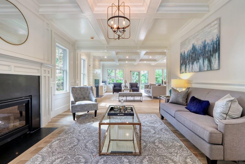 a living room with furniture a chandelier a fireplace and a large window