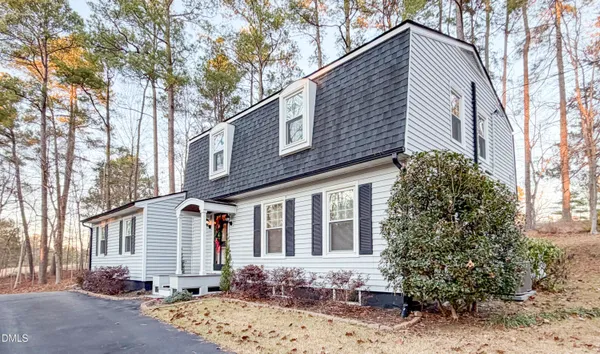 a front view of a house with a tree