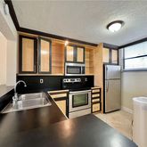 a kitchen with stainless steel appliances a stove a refrigerator and a sink with wooden floor