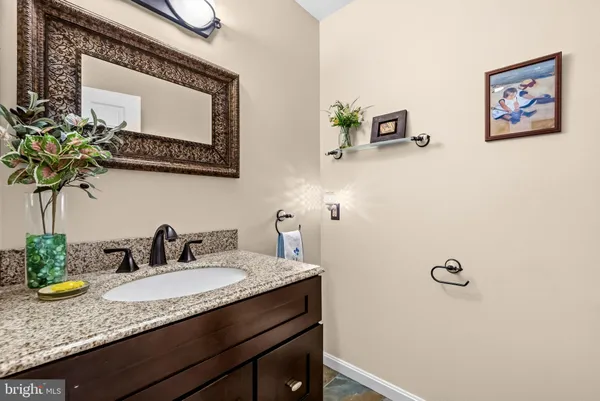 a bathroom with a granite countertop sink a mirror and vanity