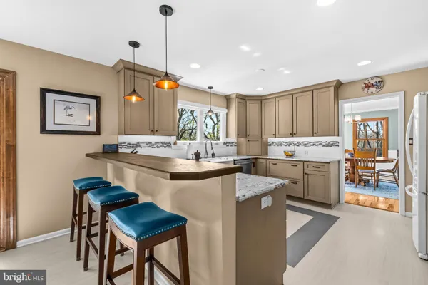 a kitchen with kitchen island granite countertop wooden cabinets and white appliances