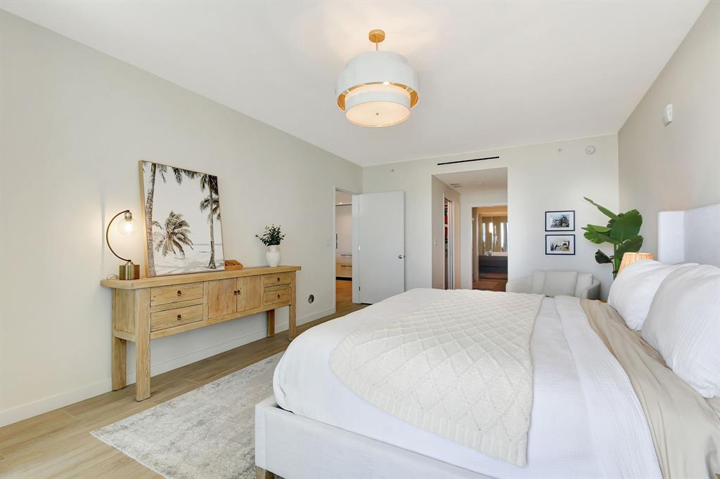 1116 North Ocean Boulevard, Unit 303 Pompano Beach, FL 33062 - Photo 19 of 52 a bedroom with a bed and wooden floor