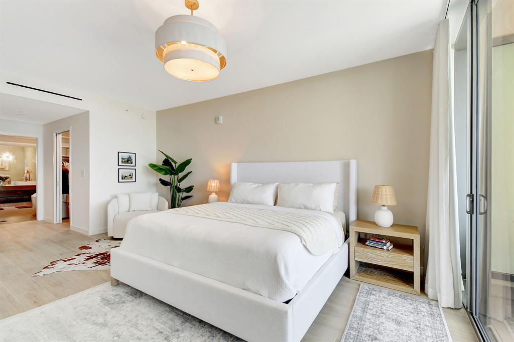 1116 North Ocean Boulevard, Unit 303 Pompano Beach, FL 33062 - Photo 20 of 52 a bedroom with a bed and a chandelier