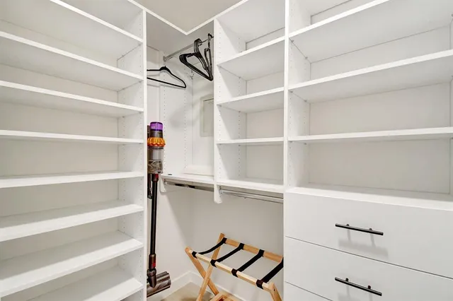 a view of walk in closet with empty racks