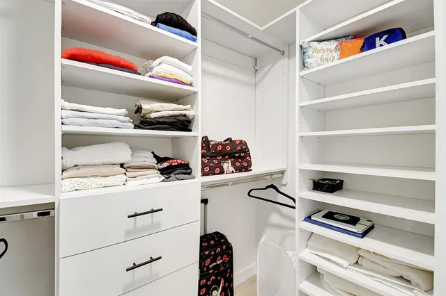 a view of walk in closet with clothes and shoes