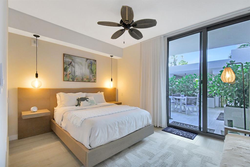 1116 North Ocean Boulevard, Unit 303 Pompano Beach, FL 33062 - Photo 32 of 52 a bedroom with a bed and a chandelier