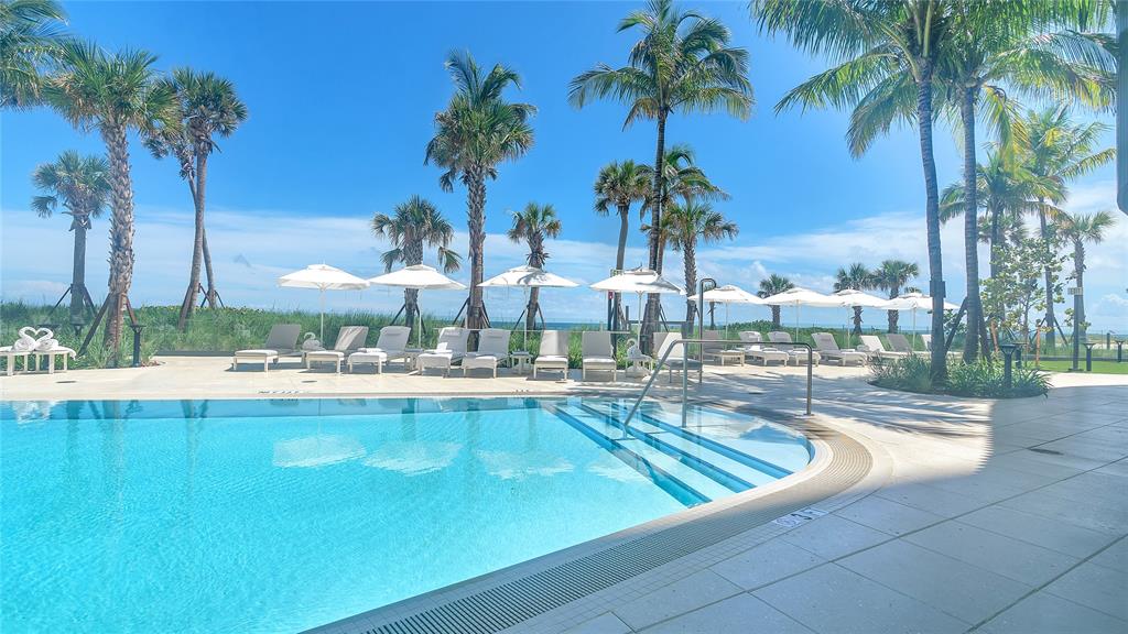 1116 North Ocean Boulevard, Unit 303 Pompano Beach, FL 33062 - Photo 41 of 52 a view of swimming pool with outdoor seating and palm trees