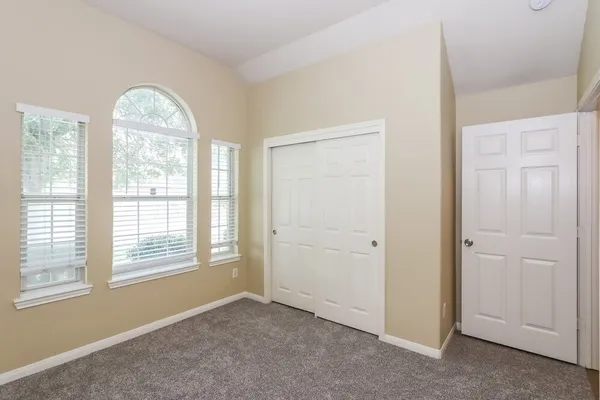 an empty room with windows and closet