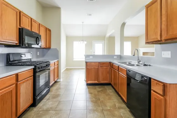 a large kitchen with stainless steel appliances granite countertop a sink and dishwasher a stove top oven with wooden floor
