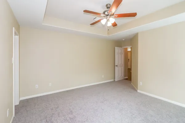 an empty room with a ceiling fan and a window