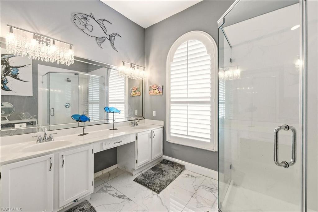 209 Countryside Drive Naples, FL 34104 - Photo 24 of 50 Bathroom with a marble finish shower, double vanity, and light marble finish flooring