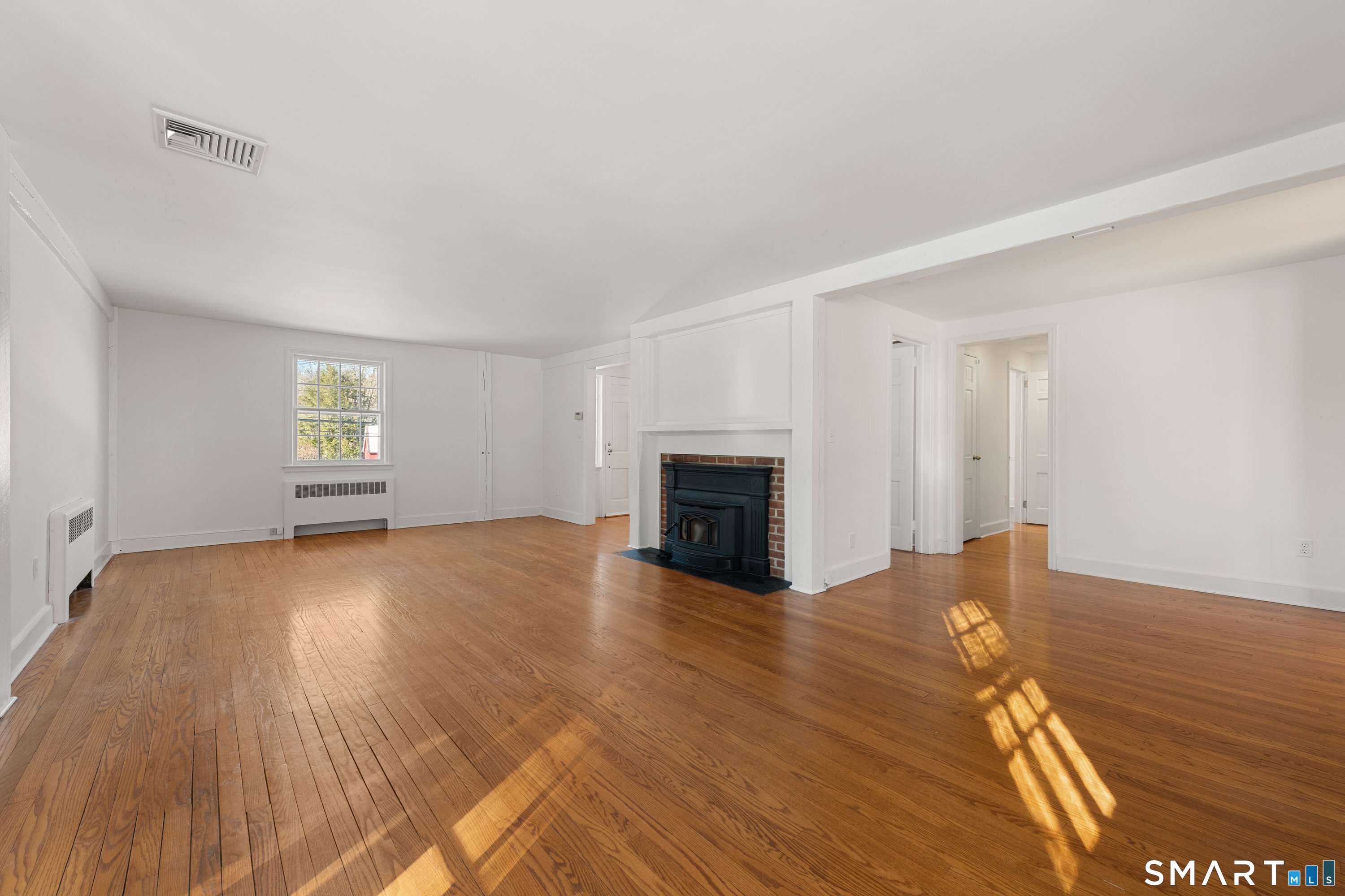 111 Lyons Plain Road Weston, CT 06883 - Photo 5 of 25 a view of empty room with wooden floor and fireplace