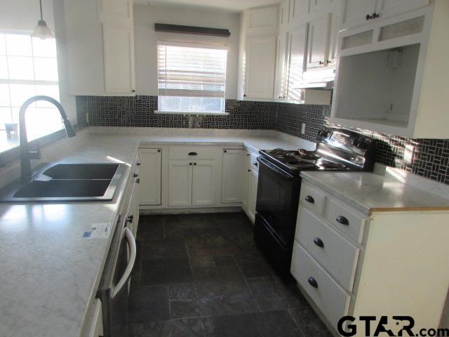 983 Nandena Road Gilmer, TX 75644 - Photo 5 of 9 a kitchen with granite countertop a sink stove and cabinets