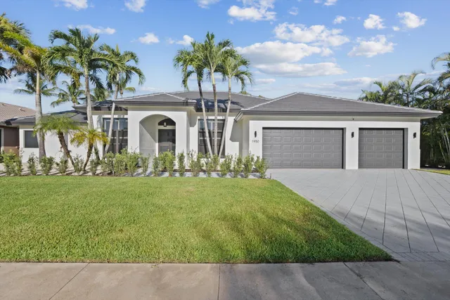 front view of house with a yard and potted plants