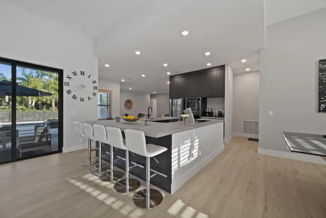 a large white kitchen with a large window and white stainless steel appliances