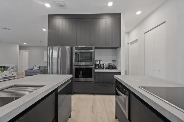 a large kitchen with a large counter top stainless steel appliances and cabinets