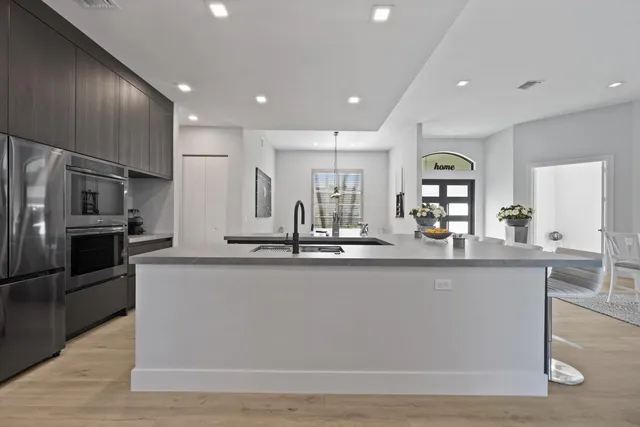 a large kitchen with granite countertop a large counter top stainless steel appliances and cabinets