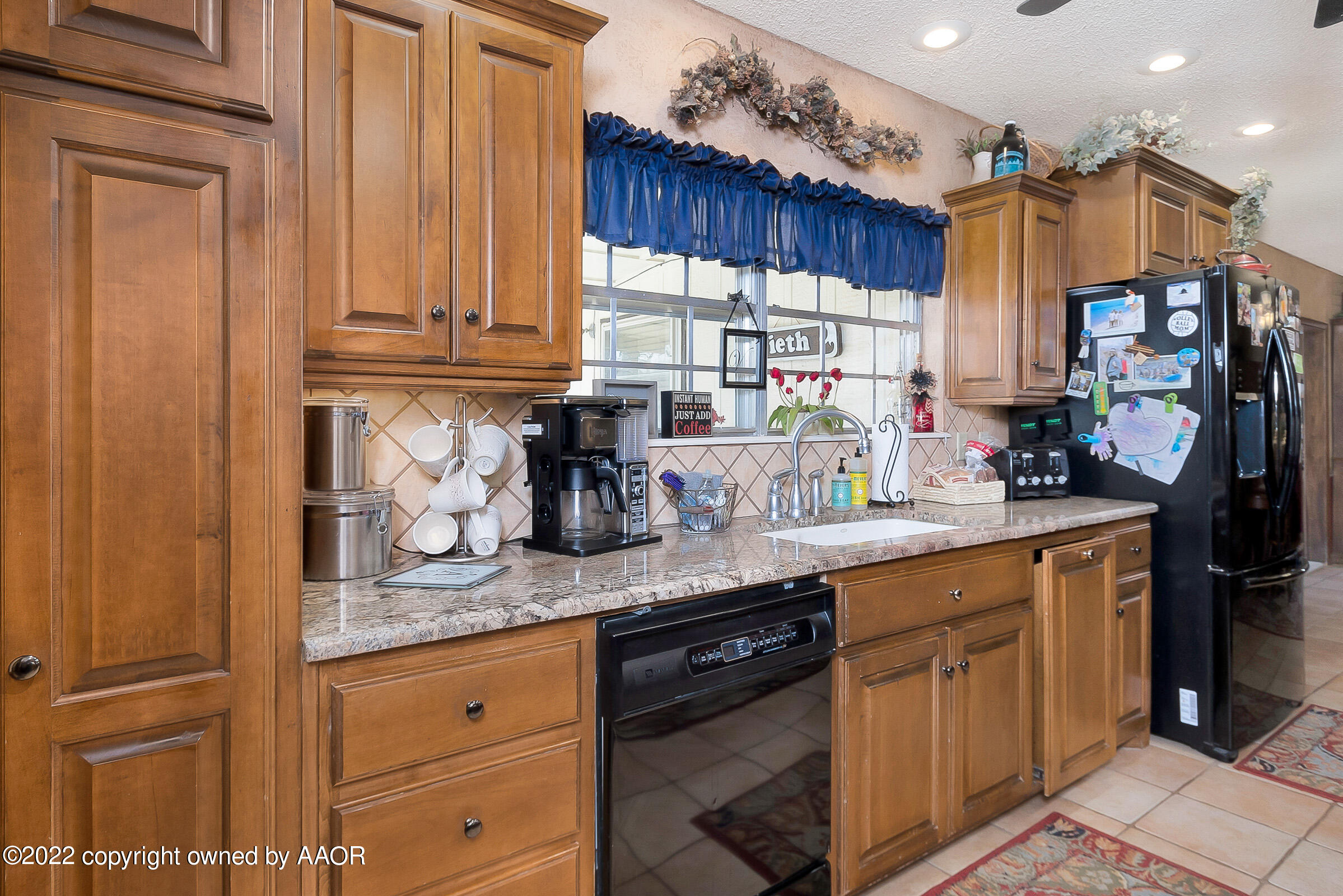 3310 Conner Drive Canyon, TX 79015 - Photo 9 of 24 a kitchen with stainless steel appliances granite countertop a sink a stove and a wooden cabinets