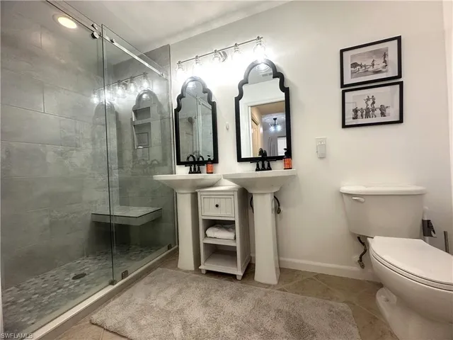 a bathroom with a double vanity sink toilet and mirror