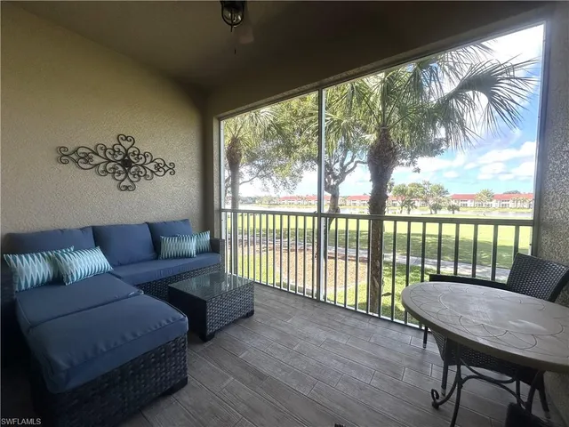 a living room with furniture and a floor to ceiling window