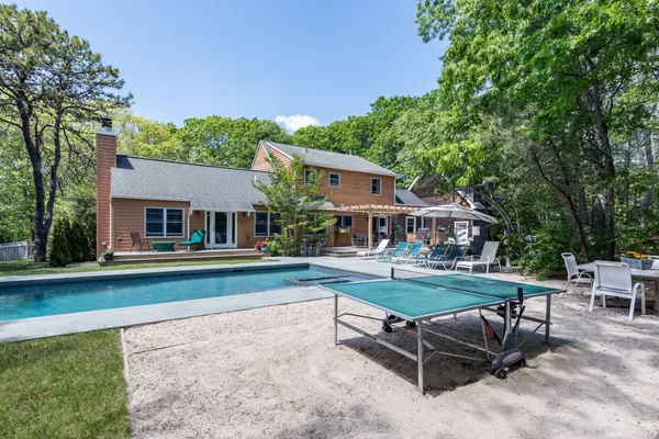 a view of a house with backyard sitting area and garden