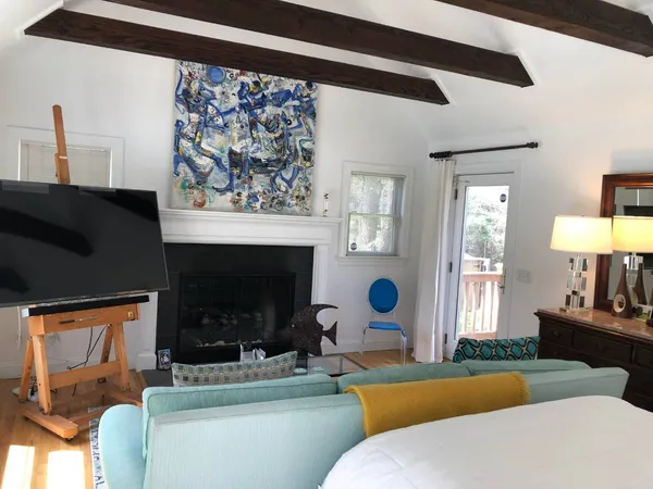 a living room with furniture a fireplace and a large mirror