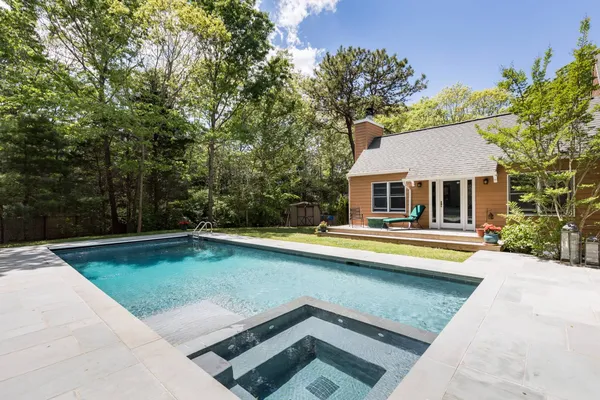 a view of a house with swimming pool and sitting area