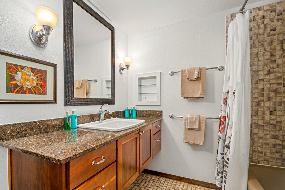 1870 Hoone Road, Unit 602 Koloa, HI 96756 - Photo 16 of 26 a bathroom with a granite countertop sink a toilet and a mirror