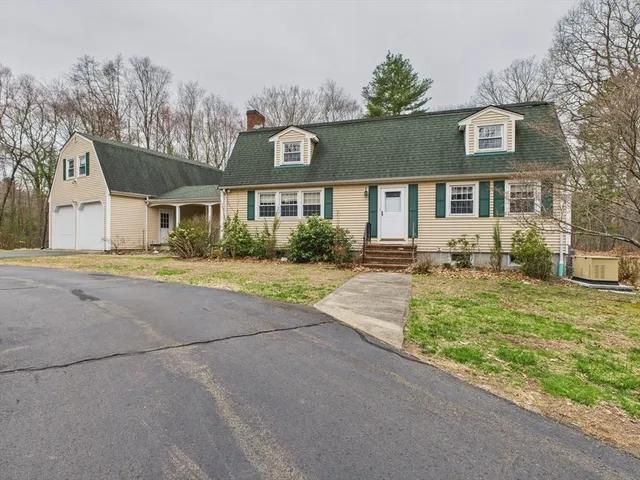 a front view of a house with a yard and potted plants