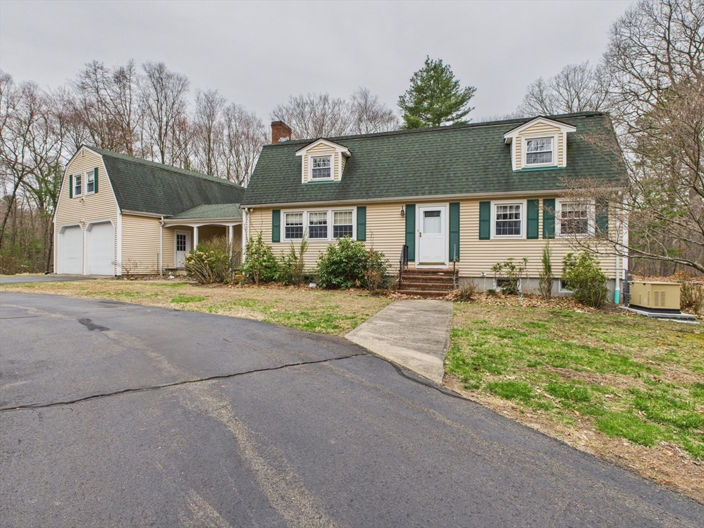 a front view of a house with a yard and potted plants