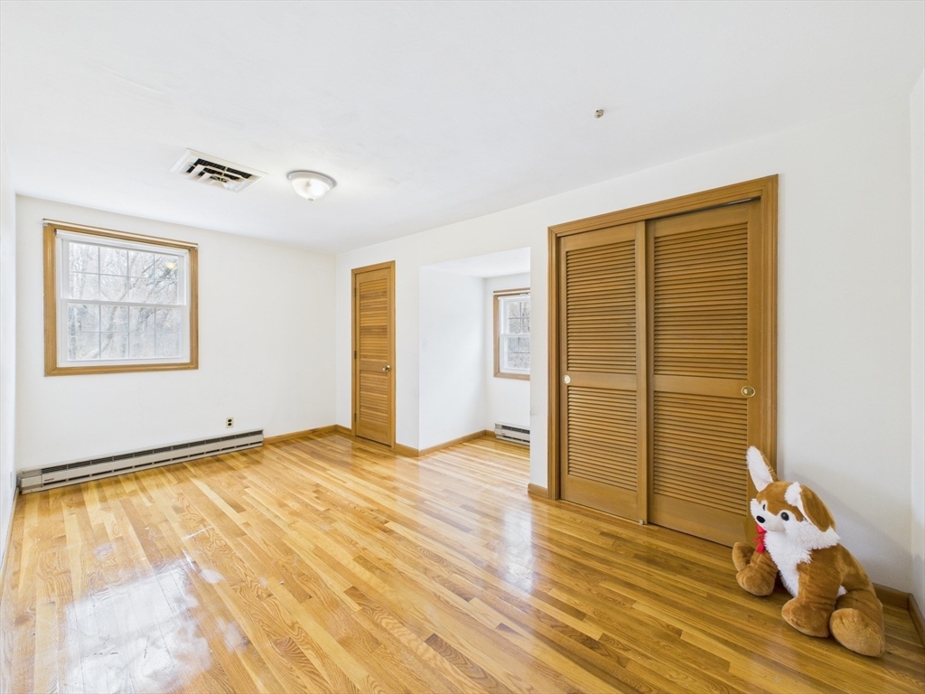 215 Stoney Lea Road Dedham, MA 02026 - Photo 19 of 27 a view of an empty room with wooden floor and a window