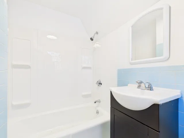 a bathroom with a sink mirror and a bathtub