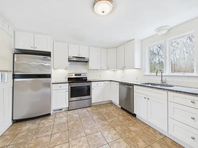 a kitchen with granite countertop a refrigerator and a sink