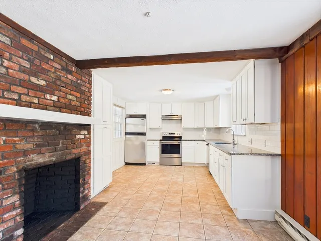 a large kitchen with stainless steel appliances granite countertop a stove and a refrigerator