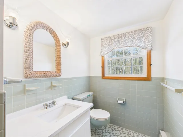 a bathroom with a sink mirror and a toilet