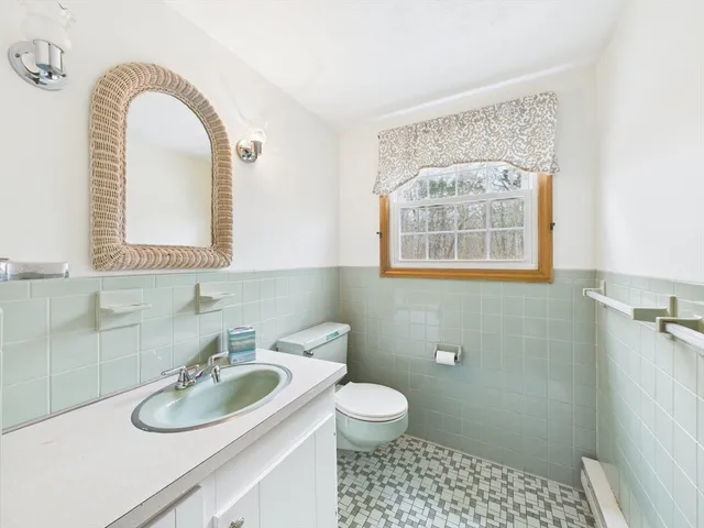 a bathroom with a sink toilet and a window